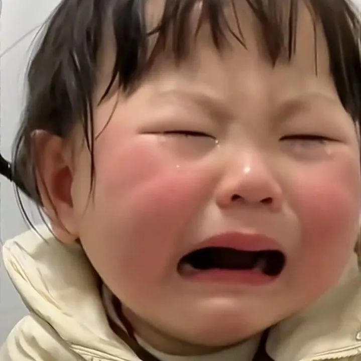 Bé gái ôm mặt khóc, dáng ngồi bé nhỏ buồn rầu.