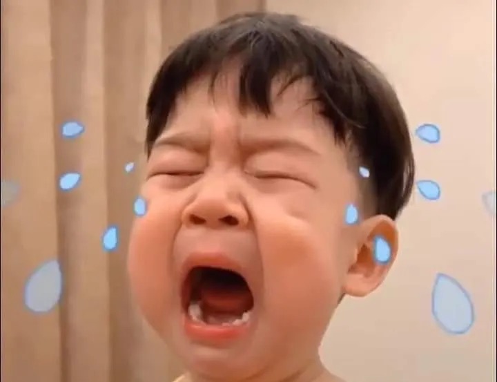 Bé trai khóc trong lòng, ánh mắt buồn man mác.