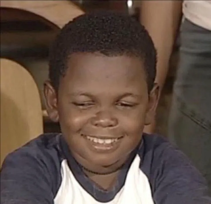 Nét mặt em bé da đen dí dỏm cười.