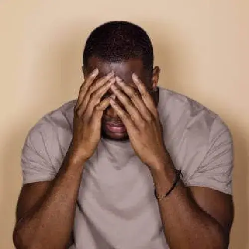 Hình chế người đàn ông da màu ôm đầu sốc nặng