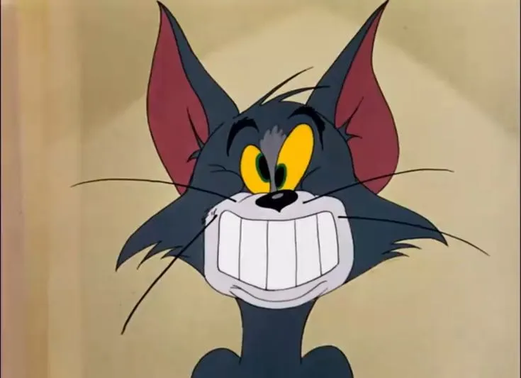 Meme Tom cười gượng gạo nhe răng