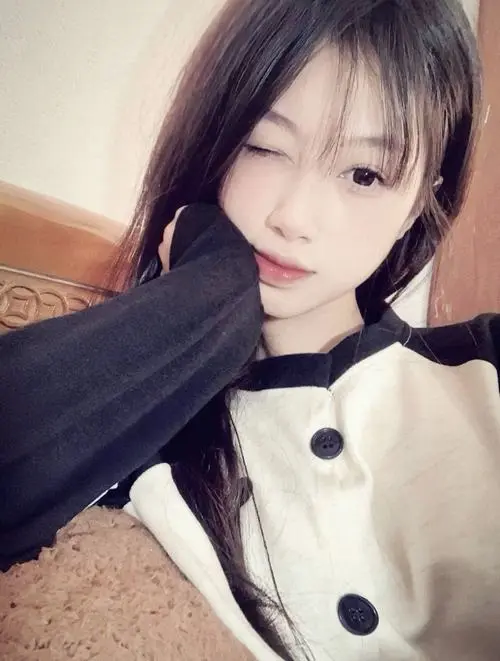 38 Bạn nữ nằm nghiêng trên gối với áo sáng có cổ đen, tóc tím nâu phủ qua má và mắt nhìn lơ đãng, khung hình 2k5 này hợp làm hình profile vì mặt lên rất nét