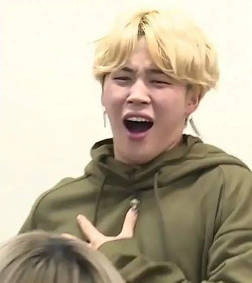 26 Chàng trai tóc vàng ngoài trời ngửa nhẹ đầu, tay chạm ngực và cười lớn, ánh sáng xanh lá phía sau làm ảnh chế nghẹt thở trông tươi mà vẫn lố