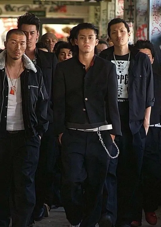 51 Đám thanh niên bước đi dứt khoát trên đường phố vắng người, dáng vẻ của những đại ca cầm đầu khiến không gian xung quanh như bị nén lại.