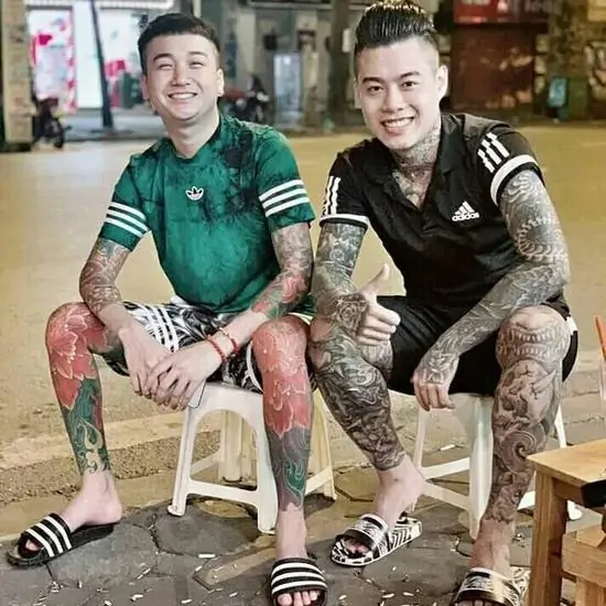 43 Hai anh em ngồi cạnh nhau trên chiếc ghế nhựa vỉa hè, nụ cười sảng khoái xua tan đi vẻ ngoài dữ dằn thường thấy của dân trong giới.