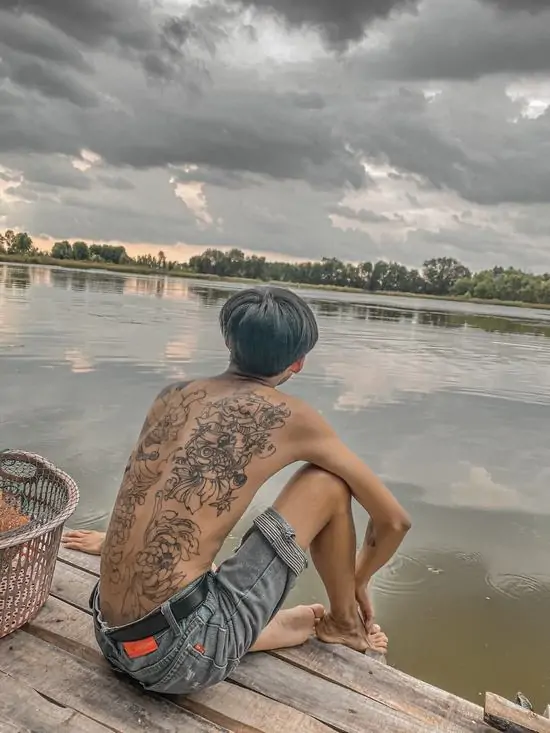 48 Ảnh đại diện ngầu nam chính ngồi bên bờ sông lúc hoàng hôn buông xuống, bóng lưng vững chãi toát lên vẻ điềm tĩnh và đầy chiều sâu trải nghiệm.