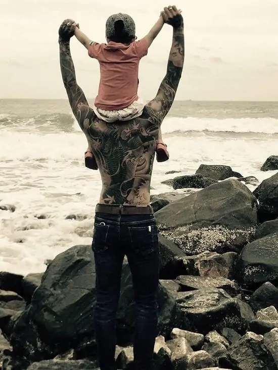 33 Người đàn ông xăm trổ cõng đứa con nhỏ trên vai đi dọc bờ biển, khoảnh khắc ấm áp làm mềm đi vẻ gai góc của một gã giang hồ.