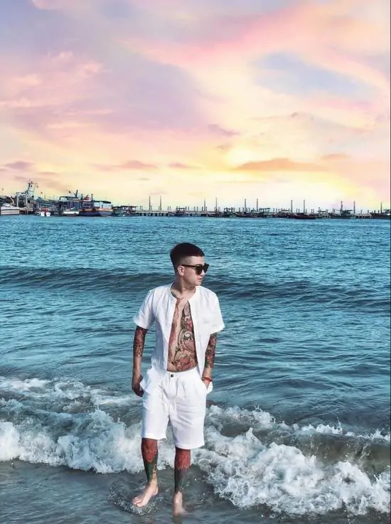 35 Chàng trai trẻ đứng trước biển cả mênh mông lúc hoàng hôn, chiếc áo sơ mi phanh ngực lộ rõ vẻ ngang tàng và khát khao tự do mãnh liệt.