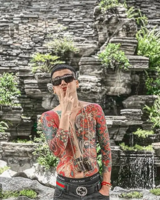 10 Chàng trai cởi trần đứng giữa bãi cỏ rộng, khoe khéo những đường nét nghĩa khí được khắc họa qua lớp mực xăm đầy tinh tế và sành điệu.