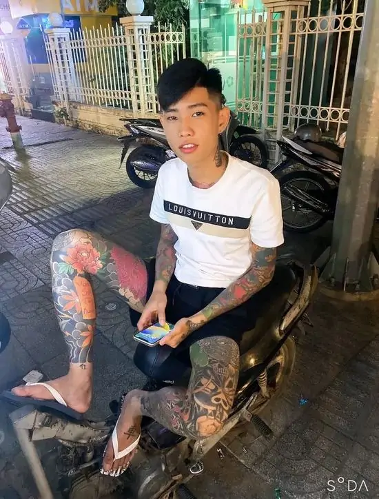 12 Nam chính ngồi trên chiếc xe máy đen bóng, cánh tay xăm trổ đặt lên đùi đầy quyền lực làm nổi bật chất đại ca thứ thiệt.