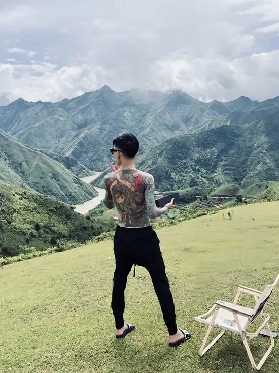 20 Một người đứng lặng lẽ giữa đồi núi trập trùng, mái tóc vuốt dựng cùng phong thái tự tại của kẻ đã đi qua nhiều sương gió cuộc đời.