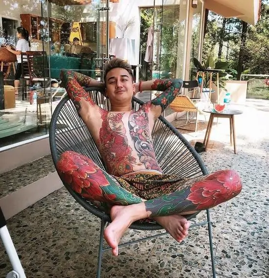 6 Người đàn ông thư giãn trên chiếc ghế mây tròn, để lộ những mảng hình xăm rồng phượng kín người đầy uy quyền và vô cùng gai góc.