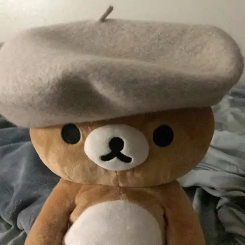 48 Một chú gấu bút chì đang ngồi xếp hình lego trên thảm caro, chân duỗi thoải mái và mắt chăm chú, kiểu ảnh này hợp làm profile gấu con cho người thích đồ chơi