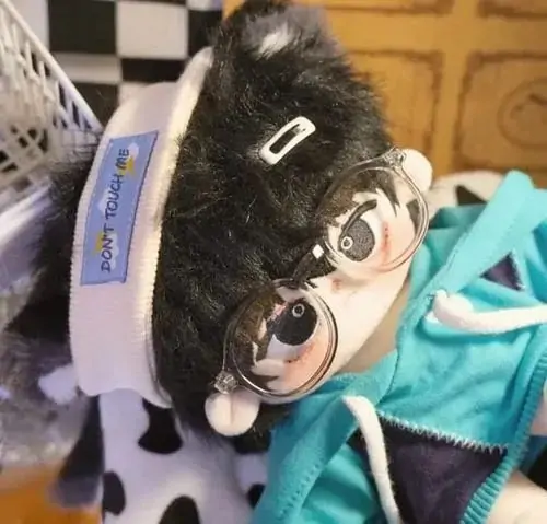 40 Một bé gấu len móc màu xanh sữa được đặt trên bệ cửa khi nắng hắt xiên qua rèm, từng mũi đan hiện rõ làm ảnh diện mạo thú bông này trông mộc mà cuốn