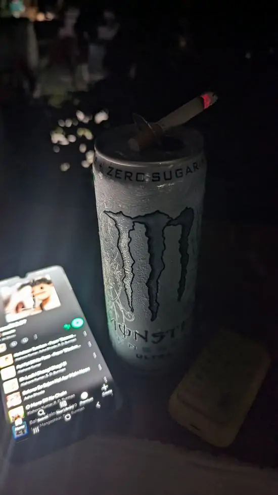 37 Hình ảnh chàng trai mặc hoodie đứng bên cửa sổ đêm, khói thuốc bay ra ngoài, mang vẻ hoang vắng.