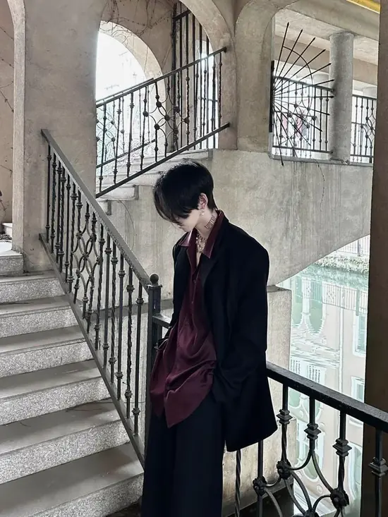 2 Trong nền văn phòng cao tầng kiểu Seoul, người đàn ông chỉnh cổ tay áo trắng, môi mím nhẹ và dáng đứng giữ khoảng cách rất rõ.