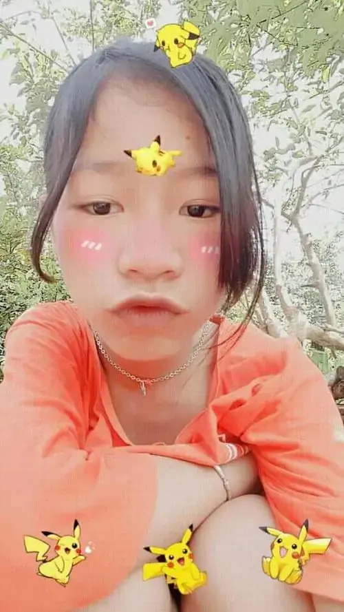 1 Cô bé áo cam chu môi dưới hiệu ứng bướm, ngồi ngoài trời với vẻ phụng phịu dễ nhớ
