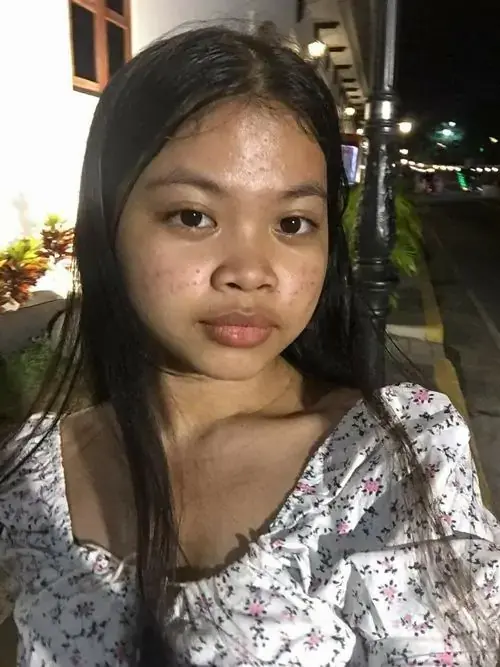 6 Dưới ánh đèn đêm, bạn nữ mặc áo hoa ngồi gần bàn, nét mặt nghiêm và tóc xõa