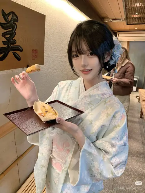 24 Bên bàn ăn kiểu Nhật, cô nàng yukata trắng xanh cầm đũa, mỉm cười khi thưởng thức món nhỏ