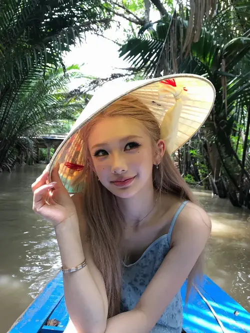 4 Bên hồ bơi nhiệt đới, cô gái tóc vàng đội nón lá cười nhẹ trong váy xanh
