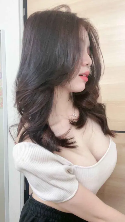 21 Góc chụp nghiêng ghi lại cô nàng tóc nâu che mặt, áo trắng cổ sâu ôm vòng 1 đầy