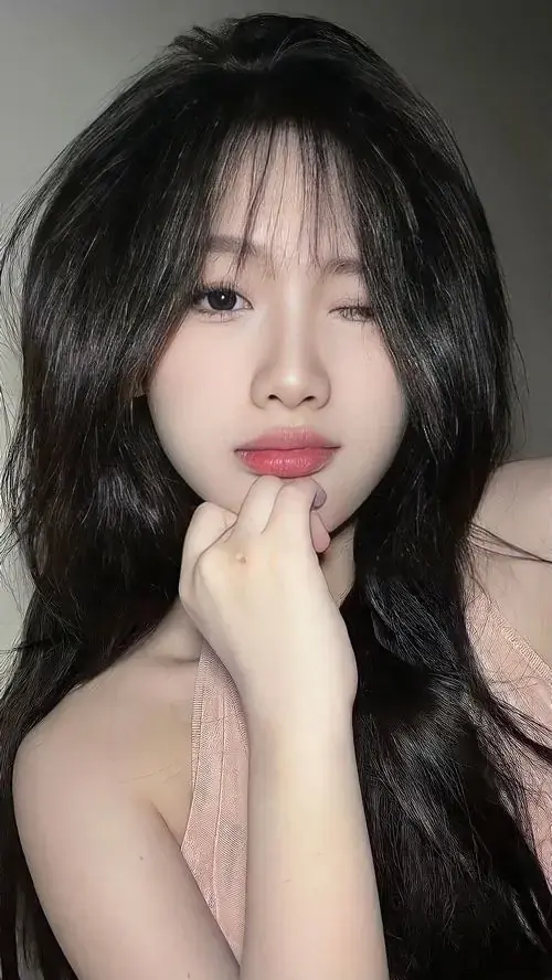 8 Bên khung cửa sáng, cô nàng tóc nâu nghiêng đầu selfie với áo hồng và nụ cười nhẹ