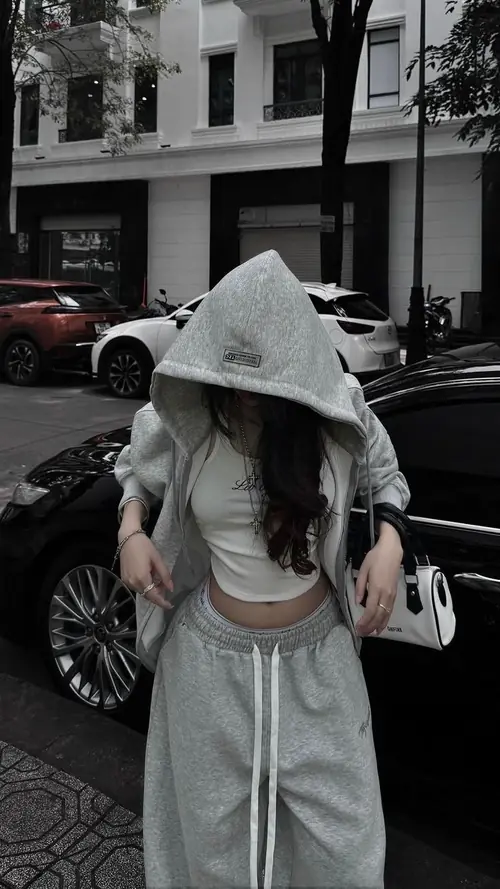 3 Giữa phố đen trắng, cô gái trùm mũ xám cúi mặt, áo croptop trắng và chân váy dài đồng bộ