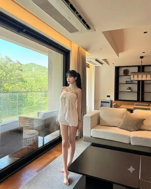 4 Ánh sáng từ khung cửa lớn phủ lên cô gái mặc váy trắng ngắn đứng trong căn phòng hiện đại