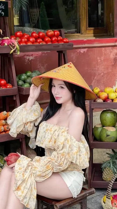 8 Giữa quầy trái cây đỏ rực, nàng đội nón lá ngồi tạo dáng trong áo hoa tay phồng