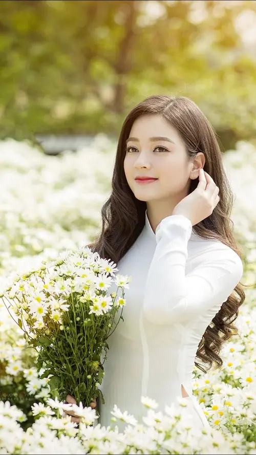 10 Dưới nắng ngoài vườn, cô gái Việt mặc áo dài trắng ôm bó hoa, gương mặt nhìn nghiêng