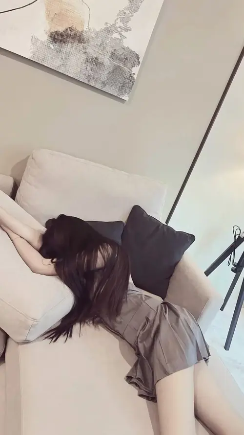 25 Góc chụp từ trên xuống ghi lại cô gái nằm trên giường, tóc dài xõa và áo sáng màu