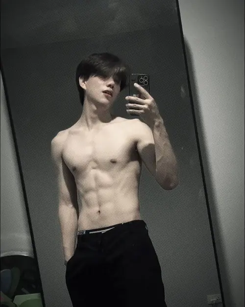 13 Chàng trai chụp mirror selfie trong không gian tối, quần đen đơn giản và dáng đứng hơi nghiêng