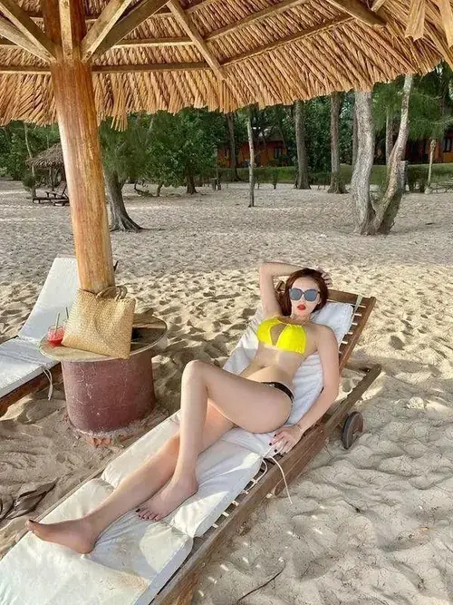 18 Bên ghế nằm trong chòi lá, cô gái mặc bikini vàng thư giãn giữa khu biển nghỉ dưỡng