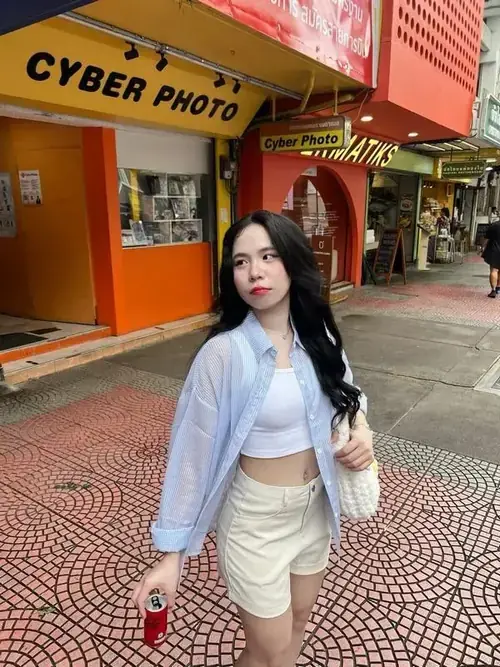 1 Sammy Đào đứng trước tiệm Cyber Photo, áo trắng chân váy kem, tóc xõa và nhìn thẳng nhẹ nhàng
