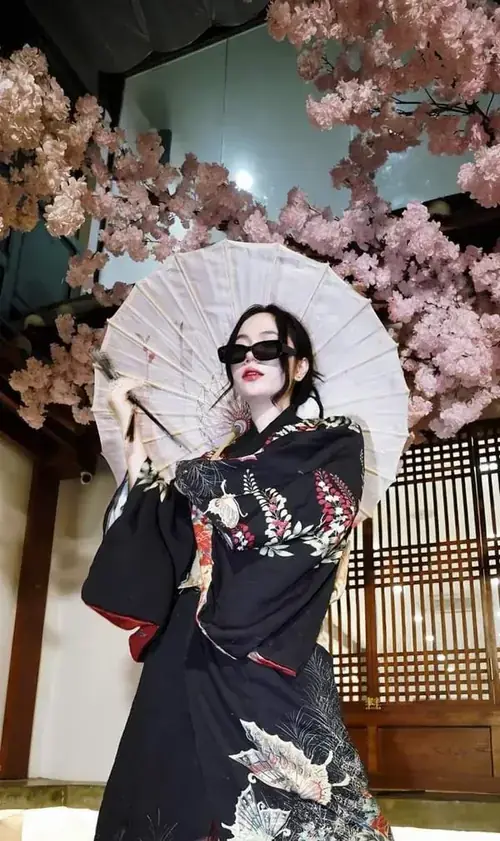 3 Mái tóc dài sau kính đen, Anh Đào cầm ô trắng giữa hoa anh đào, mặc outfit đen nổi bật