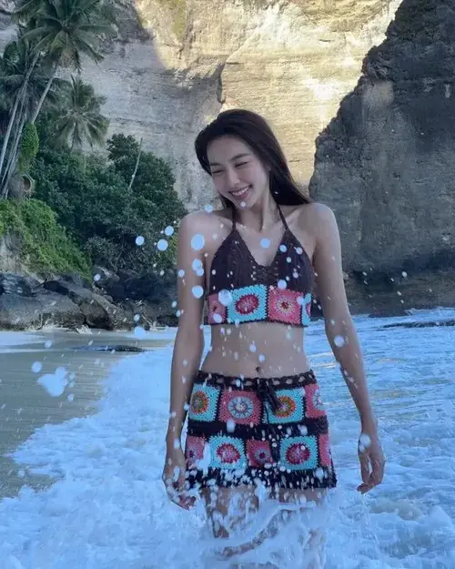 13 Miss Grand 2021 mặc váy ngắn họa tiết rực rỡ, đứng bên vách đá và cười nhẹ trước biển