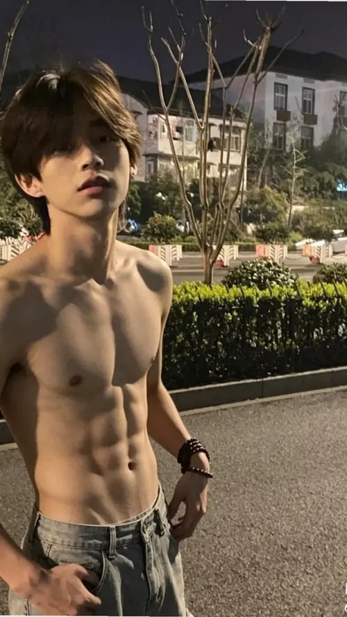 1 Chàng trai tóc rối đứng ngoài trời, để hở cơ bụng rõ nét cùng dáng vẻ trầm và khỏe khoắn