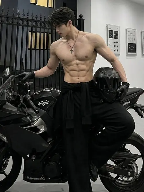 7 Chàng trai đứng cạnh mô tô đen, áo khoác mở hờ, tóc ngắn và body nam tính nổi bật