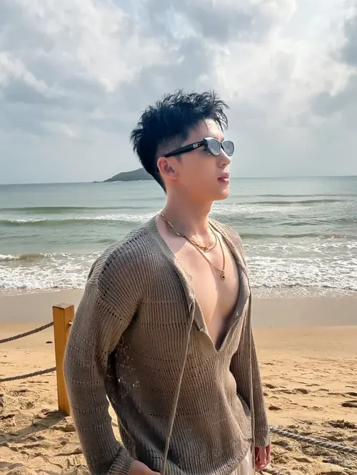 9 Chàng trai đeo kính đứng bên bờ biển, áo khoác mỏng mở cổ và ánh nhìn xa xăm