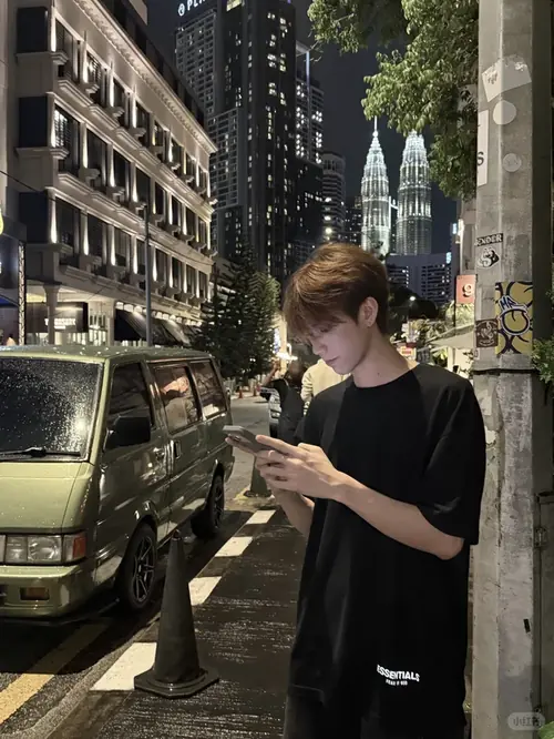 5 Cậu bạn tóc nâu mặc đồ tối đứng trên phố đêm, cúi nhìn điện thoại rất cool boy