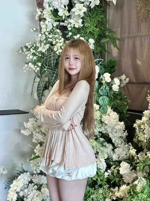 6 Trong góc hoa trắng rủ xuống, cô nàng tóc vàng mặc váy kem, khoanh tay cười hơi ngại