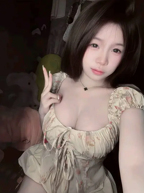 14 Tay cầm quả xanh nhỏ, bạn nữ tóc ngắn mặc váy hoa nhún trong phòng ánh tối.