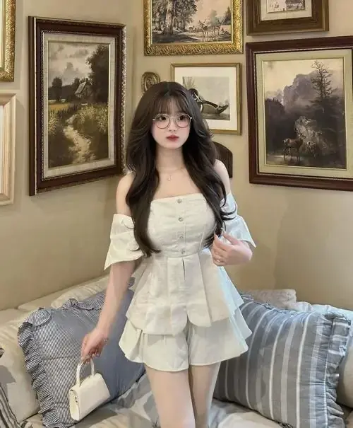 16 Trong phòng treo tranh cổ điển, người mẫu mặc set trắng phối áo khoác ngắn, tay chỉnh nhẹ trang phục