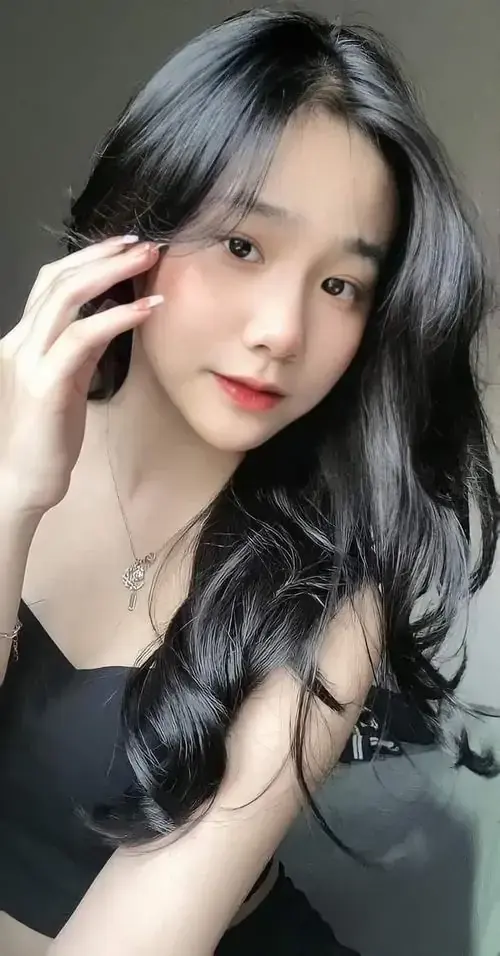 12 Dưới vành mũ lông trắng, cô gái tóc nâu mặc áo kẻ hồng nhìn thẳng camera