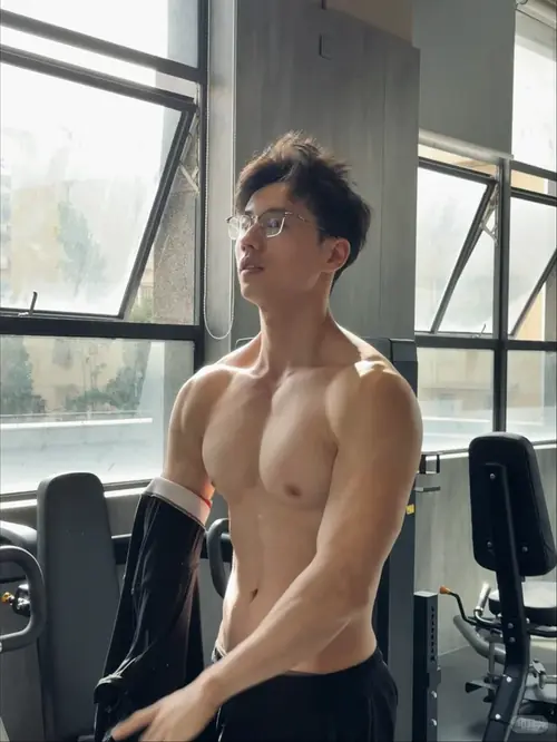 20 Cạnh cửa sổ phòng tập, trai đẹp ngồi nghiêng, áo mở sâu và gương mặt nhìn lên nhẹ