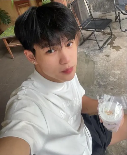 9 Chàng trai áo trắng chụp selfie trước gương, tóc đen phủ trán và không gian phòng sáng nhẹ