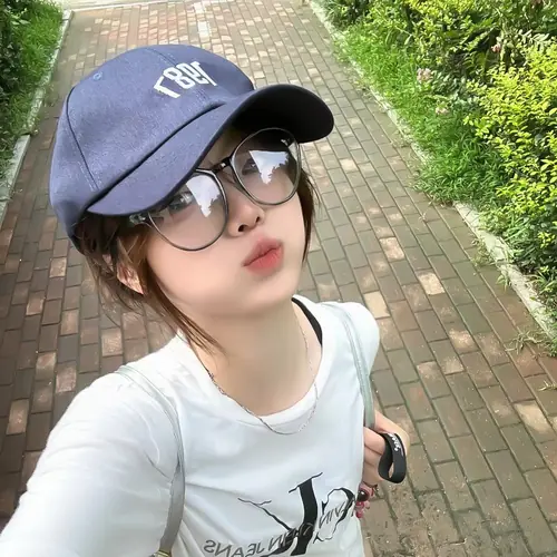 12 Từ góc chụp trên cao, bạn nữ đeo kính và mũ xanh nhìn lên lối đi lát gạch
