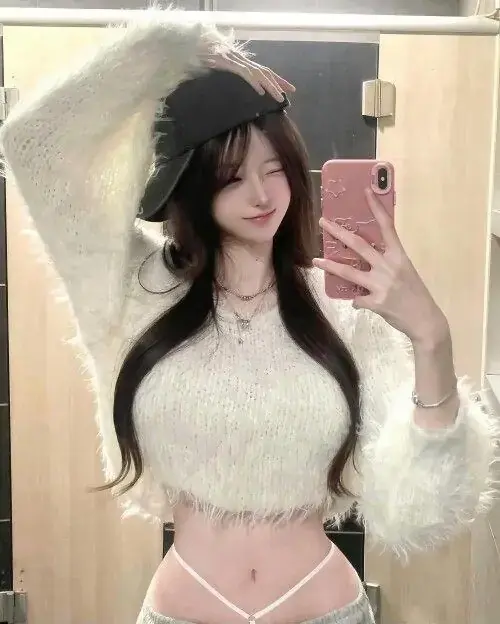 4 Cô nàng tóc đen selfie trước gương, áo lông trắng ôm dáng và biểu cảm cúi mắt dịu
