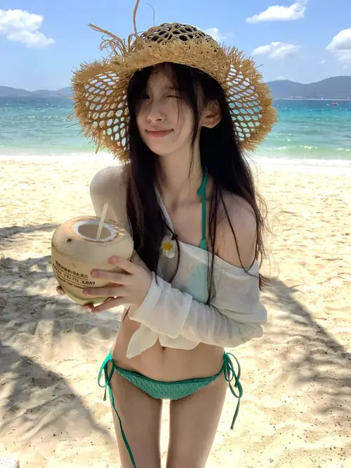 21 Mũ cói rộng đi cùng bikini xanh nhạt trên người cô gái cầm quả dừa.