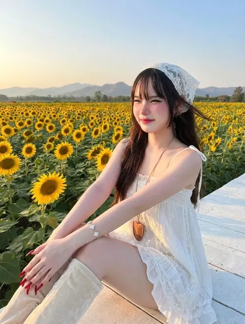 24 Bên cánh đồng hoa hướng dương, cô nàng dễ mến mặc váy trắng ngồi nghiêng, tóc dài thẳng